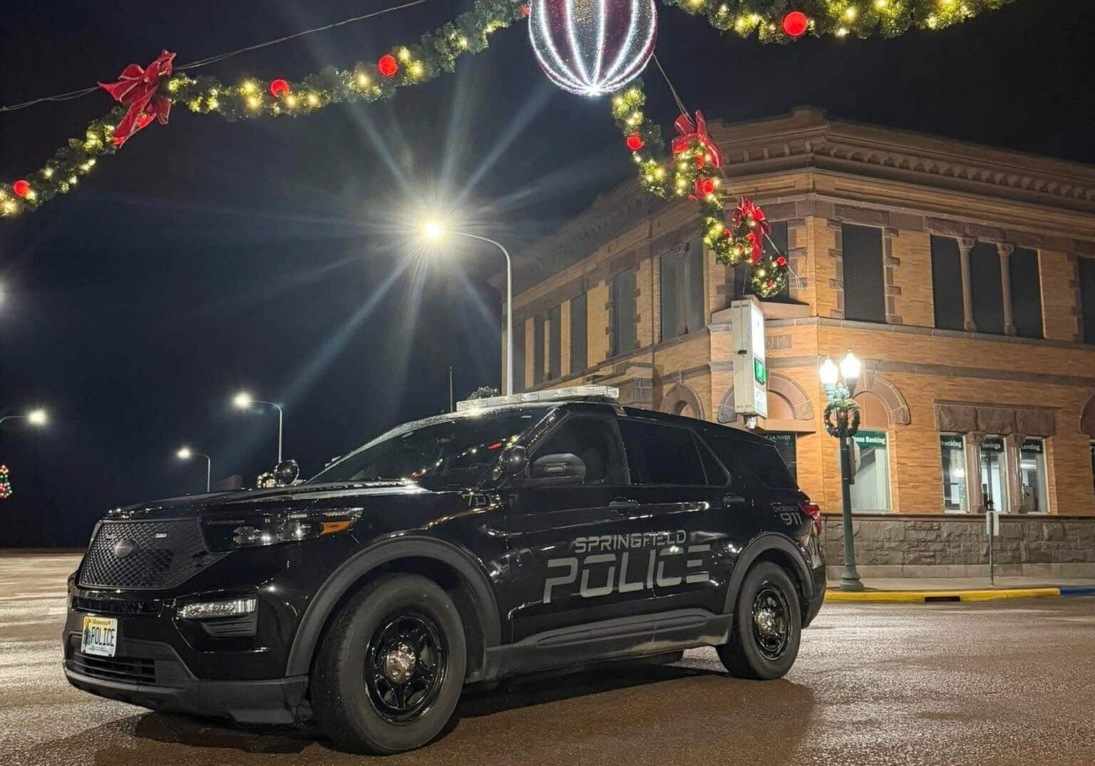 Black police car on the road with Christmas decoration